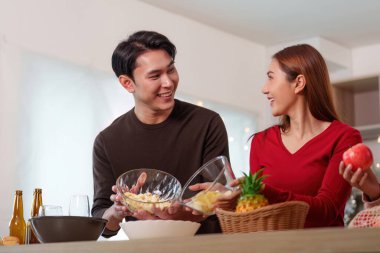 Neşeli bir arkadaş toplantısı. Yeni yıl kutlaması için yiyecek ve içecekler hazırlıyorlar. Kahkaha ve sıcaklıkla dolu..