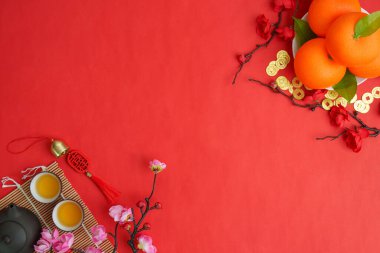 Portakal, çay fincanı ve dekoratif elementlerin renkli bir şekilde sergilenmesi, Çin Yeni Yılı için bolluk ve mutluluğu simgeliyor..