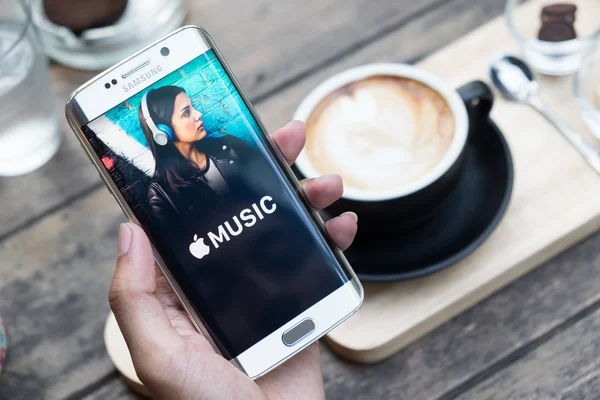 CHIANG MAI, THAILAND - NOV 20, 2015: Seorang pria memegang gambar layar dari aplikasi musik Apple yang ditampilkan pada samsung galaxy s6 edge. Apple Music adalah versi beta pada android . — Stok Foto