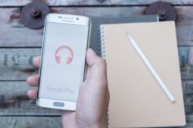 Google müzik çalma ekran görüntüsünü tutan bir adam el