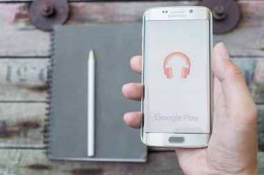 Google müzik çalma ekran görüntüsünü tutan bir adam el