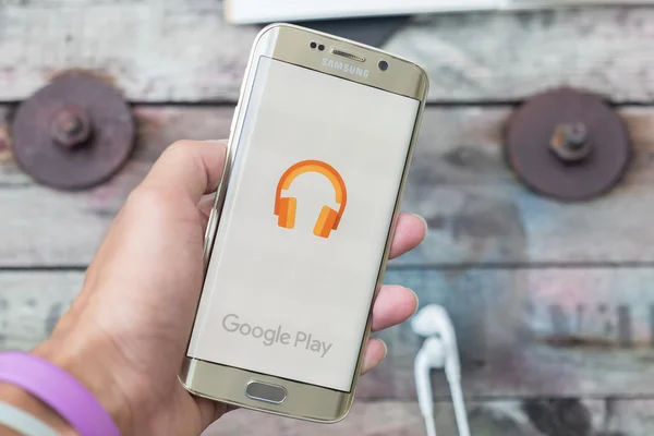 A man hand holding screen shot of google play music — Stock Photo, Image