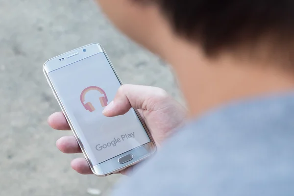 Um homem mão segurando tela tiro de música google play — Fotografia de Stock