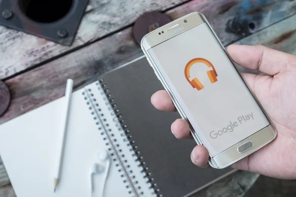 A man hand holding screen shot of google play music — Stock Photo, Image