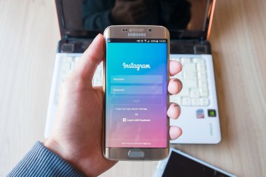 Samsung galaxy s6 kenar kullanarak Instagram uygulama ekran görüntüsünü tutan bir adam el.