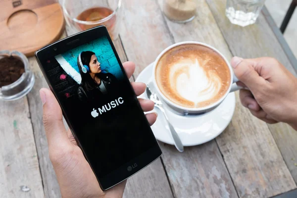 A man hand holding screen shot of Apple music app showing on lg g4. — Stock Photo, Image