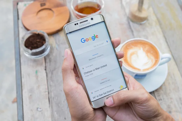 Seorang pria tangan memegang layar gambar pencarian google menunjukkan pada Samsung galaksi s6 edge . — Stok Foto