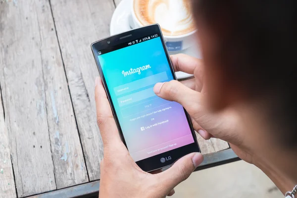 Lg g4 kullanarak Instagram uygulama ekran görüntüsünü tutan bir adam el.