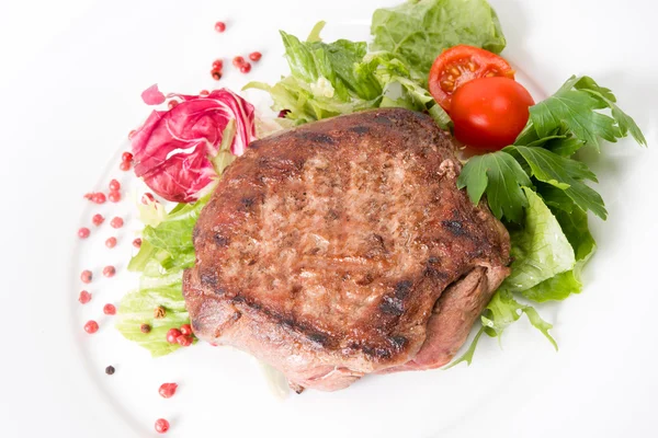 Meat stake with vegetables on a white background