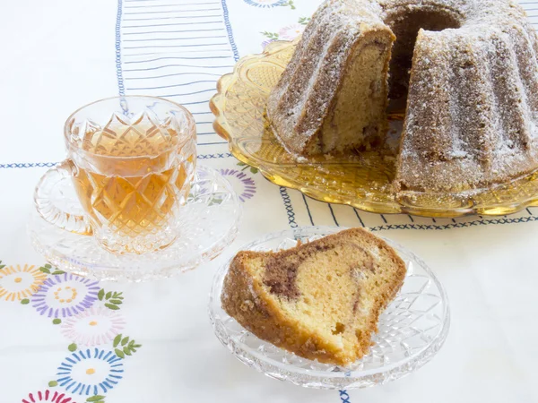 Sarı cam kase ile bir fincan çay pasta