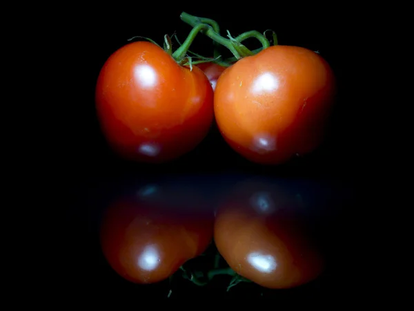 Siyah cam üzerinde üç domates