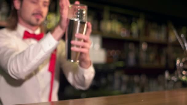 Bartender is an artist. Selective focus on a glass full of ice on the bar bartender doing tricks on the background — Stock Video