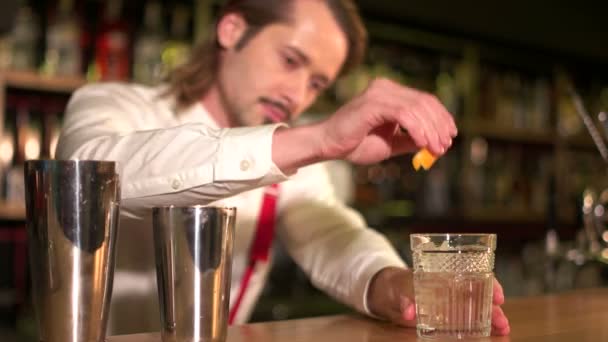 Een beetje van versheid. Barman sommige oranje citron toe te voegen aan de cocktail — Stockvideo