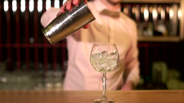 Yummy! Närbild skott av en bartendern hälla en drink till ett glas fyllt av is — Stockvideo