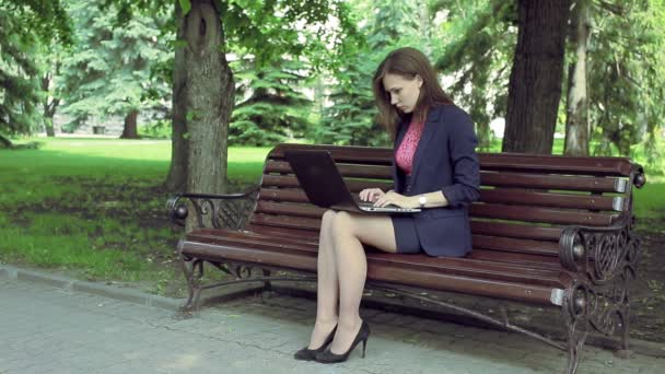 Jonge zakenvrouw met laptop werken bankje — Stockvideo