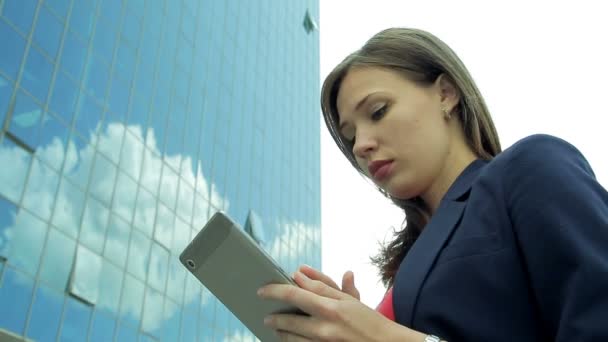 Young business woman working with tablet in front of building facade — Stock Video