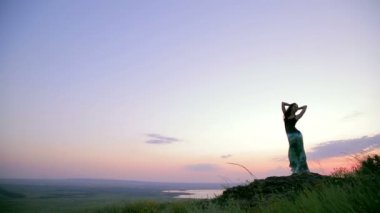 Young Woman Posing On The Rock. Evening Sky. Wide angle