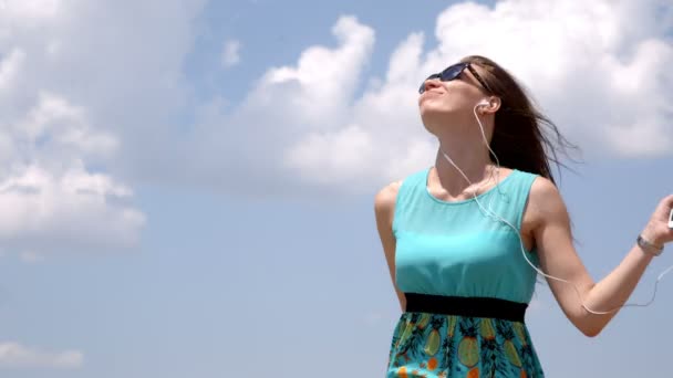 Atractiva chica bailando escuchando música a través de auriculares. De cerca. — Vídeos de Stock