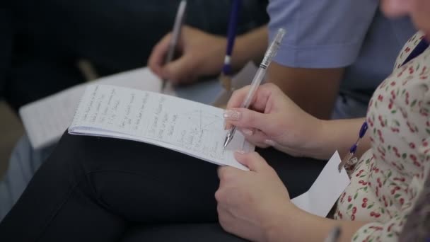 Fechar-se de mulher de negócios escreve uma caneta em um caderno — Vídeo de Stock