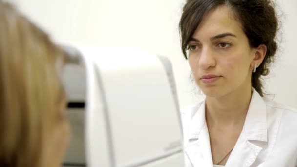 Офтальмолог перевіряє жіночі очі — стокове відео