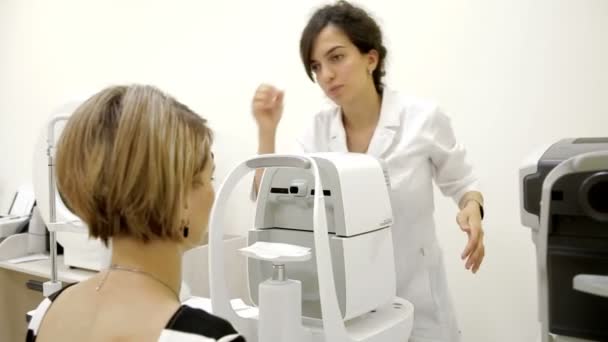 Ophthalmologist checks womans eyes — Stock Video