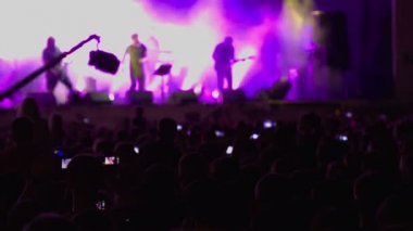 Rock konseri. Kalabalık. Sahne. Mor ışıklar