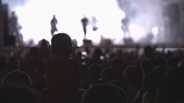 Rock konseri. Kalabalık dans. Sahne. Sanatçılar. Çocuk alkışlar