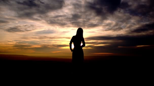 Silhouette de femme posant au coucher du soleil jaune — Video