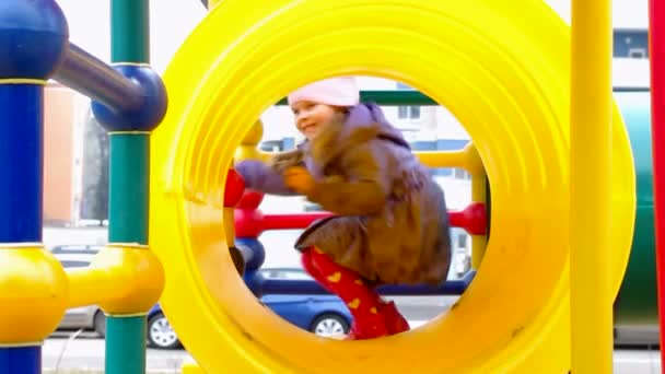 Mädchen spielt in gelber Röhre auf dem Spielplatz — Stockvideo