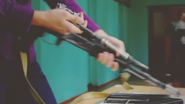 Estudiante examina el arma Kalashnikov — Vídeo de stock