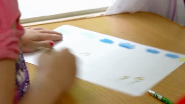 Un niño pinta sobre papel — Vídeo de stock
