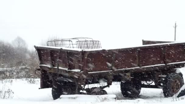 Remolque abandonado en un campo en una tormenta de nieve — Vídeos de Stock