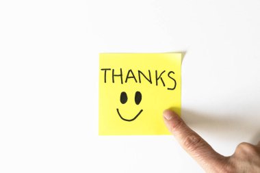 El yazısıyla yazılmış sarı yapışkan not. Tarafsız bir arkaplanda teşekkür mesajı. Günlük hayatta minnettarlığı, nezaketi ve olumlu iletişimi simgeliyor..