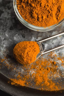 Zıt bir arkaplan üzerinde koyu bir tabakta servis edilen altın zerdeçal tozu.