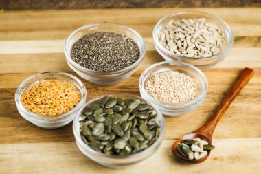 Farklı tohumlarla dolu küçük kaseler keten tohumu, chia, susam, balkabağı ve ayçekirdeği..