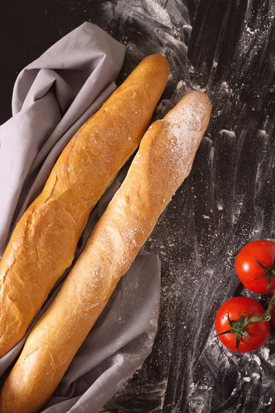 Dos de baguette francesa sobre fondo oscuro con harina — Foto de Stock