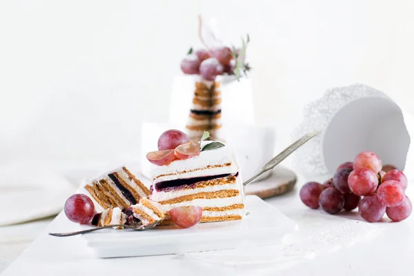 Pokroić ciasto souffle na białym tle z białej tonacji i winogron — Zdjęcie stockowe