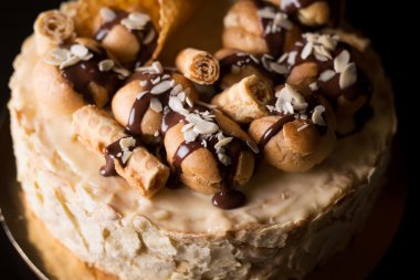 Napolyon kek koyu ahşap arka plan üzerine badem eklerleri, waffle ve çikolata sosu yaprakları ile dekore edilmiştir.