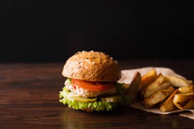 Koyu ahşap bir masa üzerinde burger