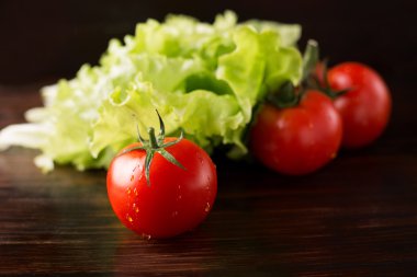 Ahşap arka planda domates ve marul.