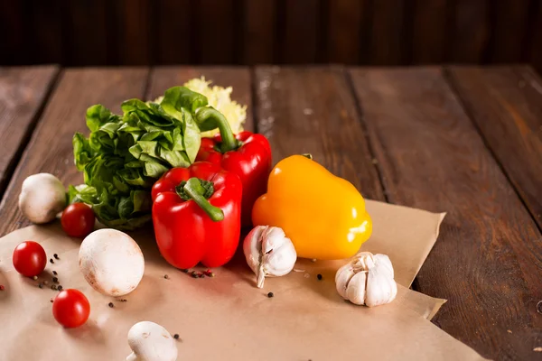 Fresh vegetables, bulgarian pepper, lettuce, garlic, mushrooms, cherry tomatoes and spices on wooden background — Stock Image Fresh vegetables, bulgarian pepper, lettuce, garlic, mushrooms, cherry tomatoes and spices on wooden background Stock Photo