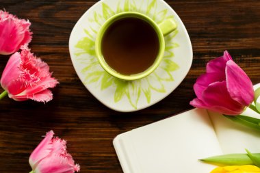 Kahvaltı. Bir fincan çay, çiçekler, ahşap arka plan ile ilgili notlar