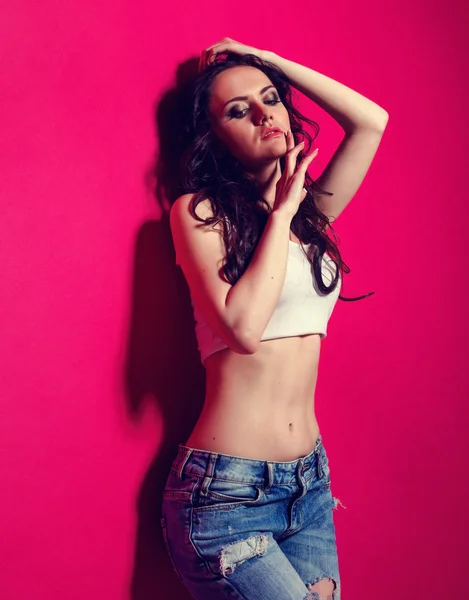 Menina elegante magro no jeans e sutiã no estúdio no fundo rosa — Fotografia de Stock