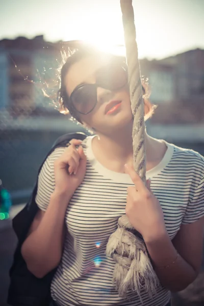 Стильная девушка-хипстер в джинсах и солнцезащитных очках в городе — стоковое фото