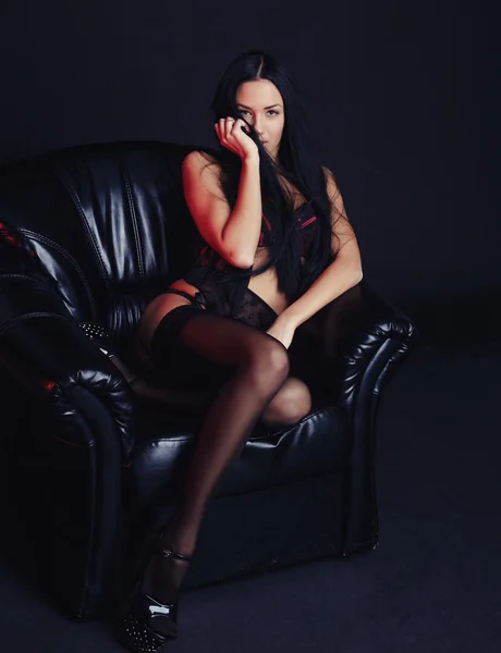Сексуальная девушка в нижнем белье на кожаном стуле — стоковое фото