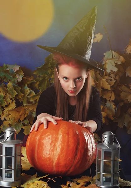 Petite fille en costume d'Halloween de la sorcière avec la citrouille et la lanterne faire sortiller — Photo