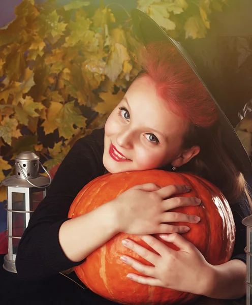 Bambina in costume di Halloween della strega con la zucca e la lanterna fanno incantesimo evocare — Foto Stock