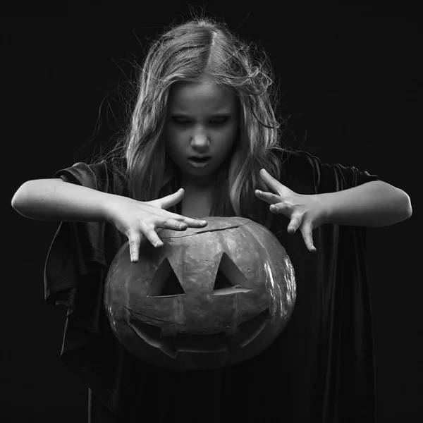 Petite fille en costume d'Halloween de la sorcière avec la citrouille faire sort évoquer — Photo