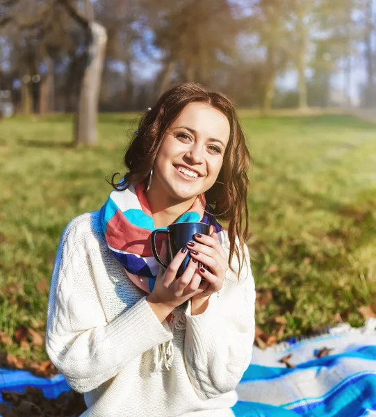 Stijlvolle hipster lachende meisje student met kopje koffie of thee in het park buiten — Stockfoto