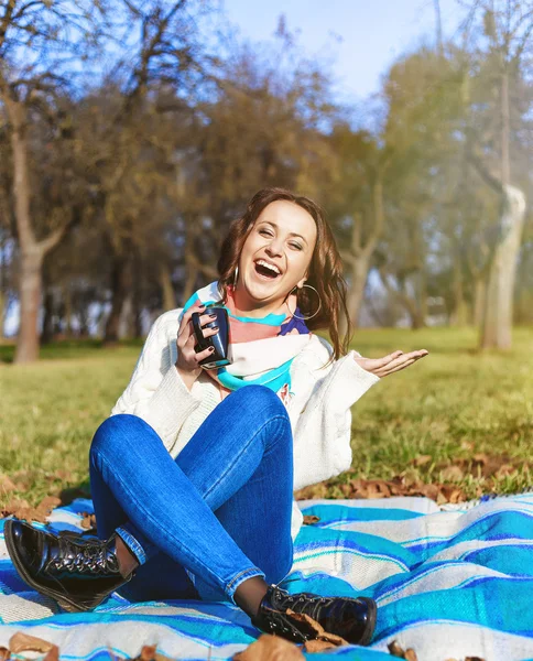 Stijlvolle hipster lachende meisje student met kopje koffie of thee in het park buiten — Stockfoto